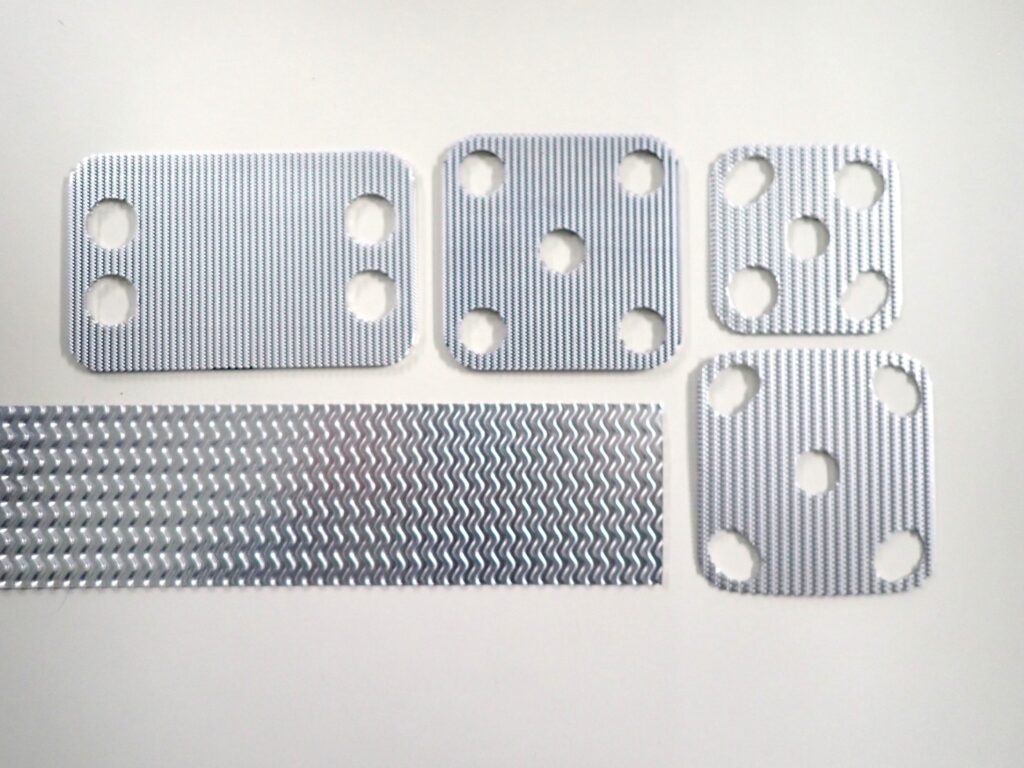 アルミ薄板0.2mmを量産する順送プレス技術｜オイルクーラー部品向け