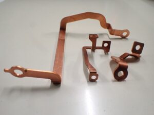 C1020およびC1100材を使用した板厚1.0mm、1.5mm、2.0mmの銅バスバー製品。順送プレス金型により、銅特有の型傷を抑え、高い直角度と穴ピッチ精度を実現した外観。