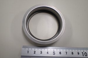 SUS304（t0.25mm）を用いた水筒の内筒口金部品。外形寸法を維持しながら内径ヘミングの径・高さ・角度を安定させた順送プレス金型による加工サンプル。